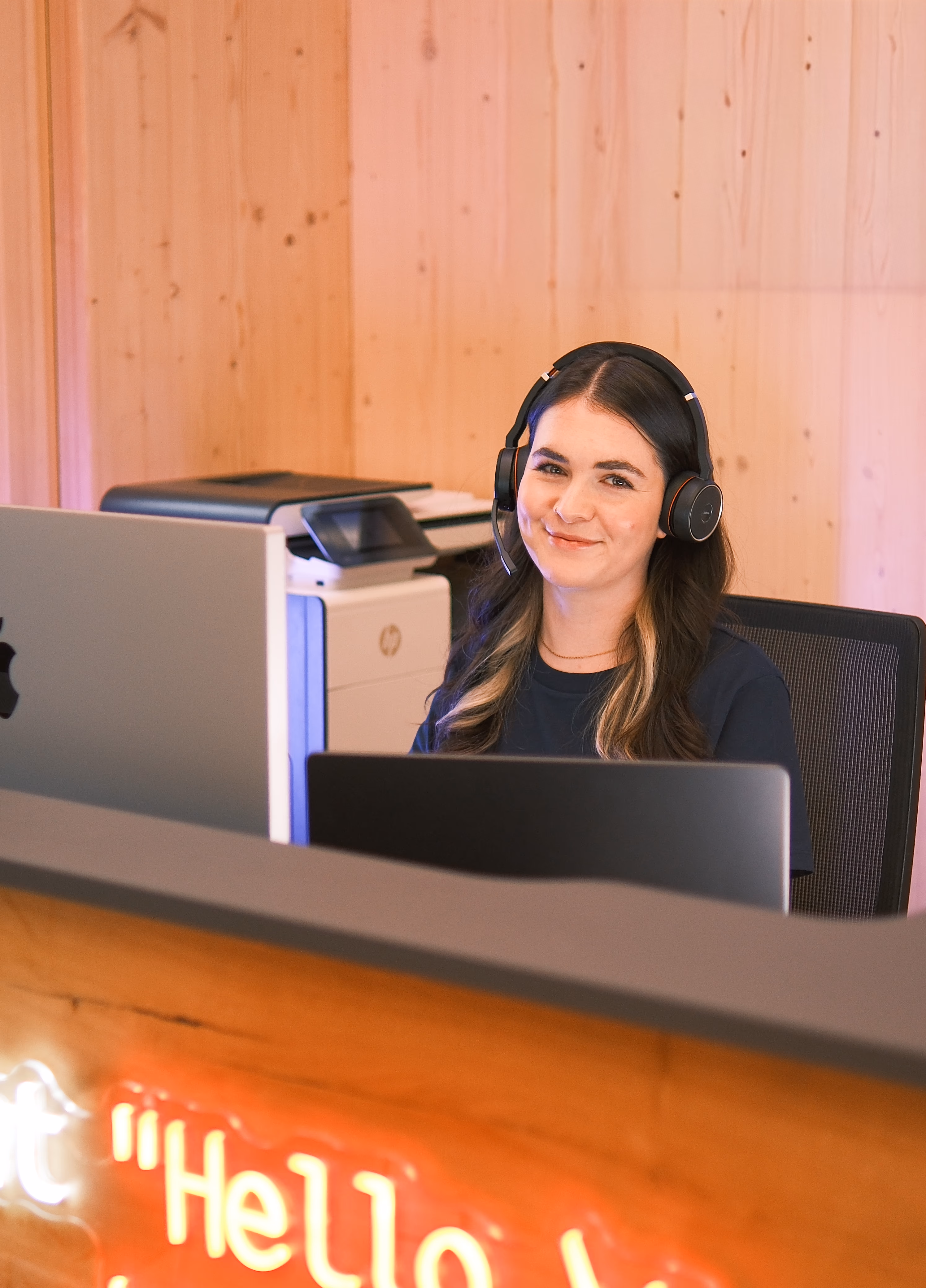 Mitarbeiterin im Kundenservice von aushang-digital.de mit Headset am Schreibtisch